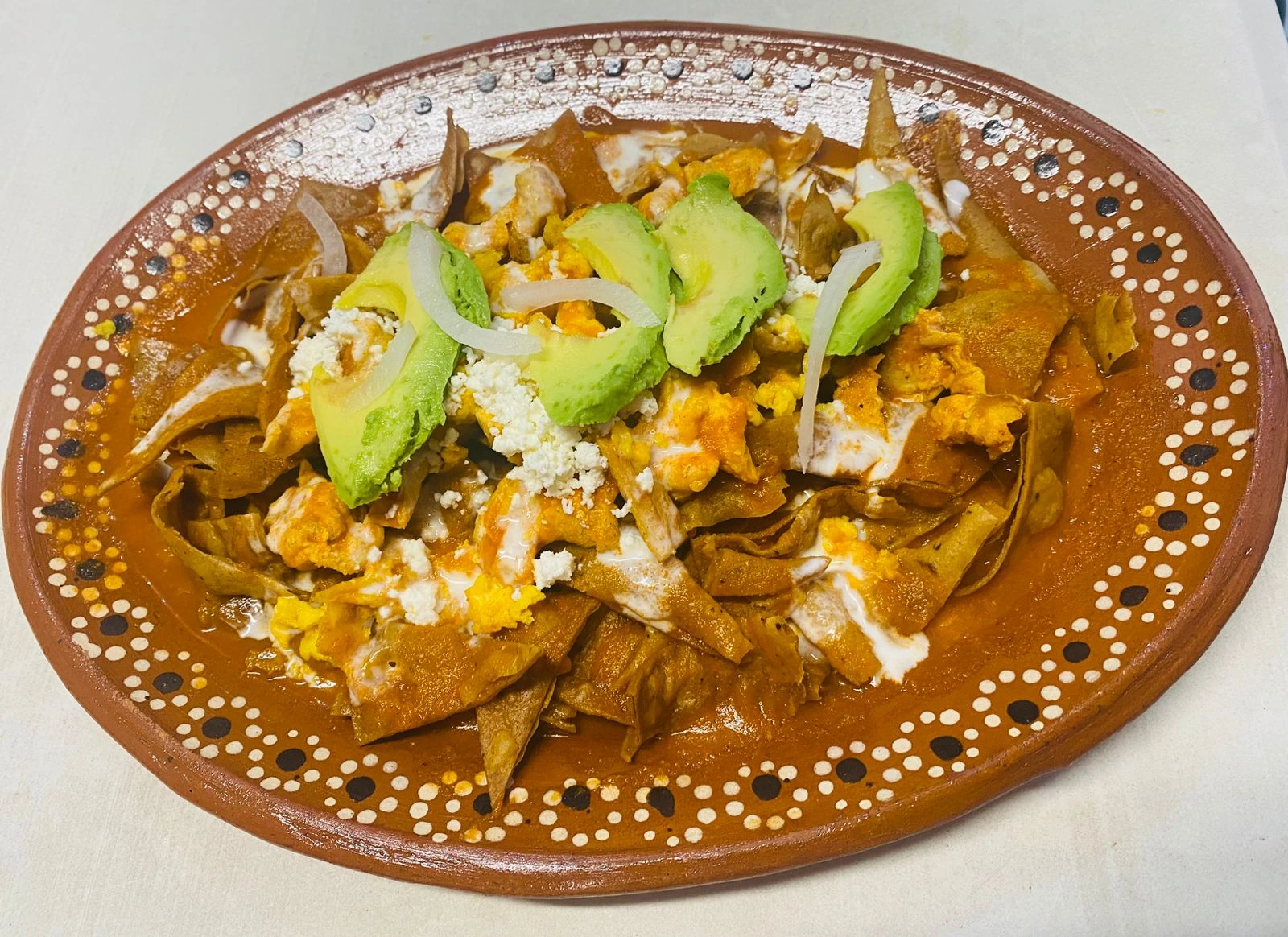 Chilaquiles con aguacate, cebolla y queso