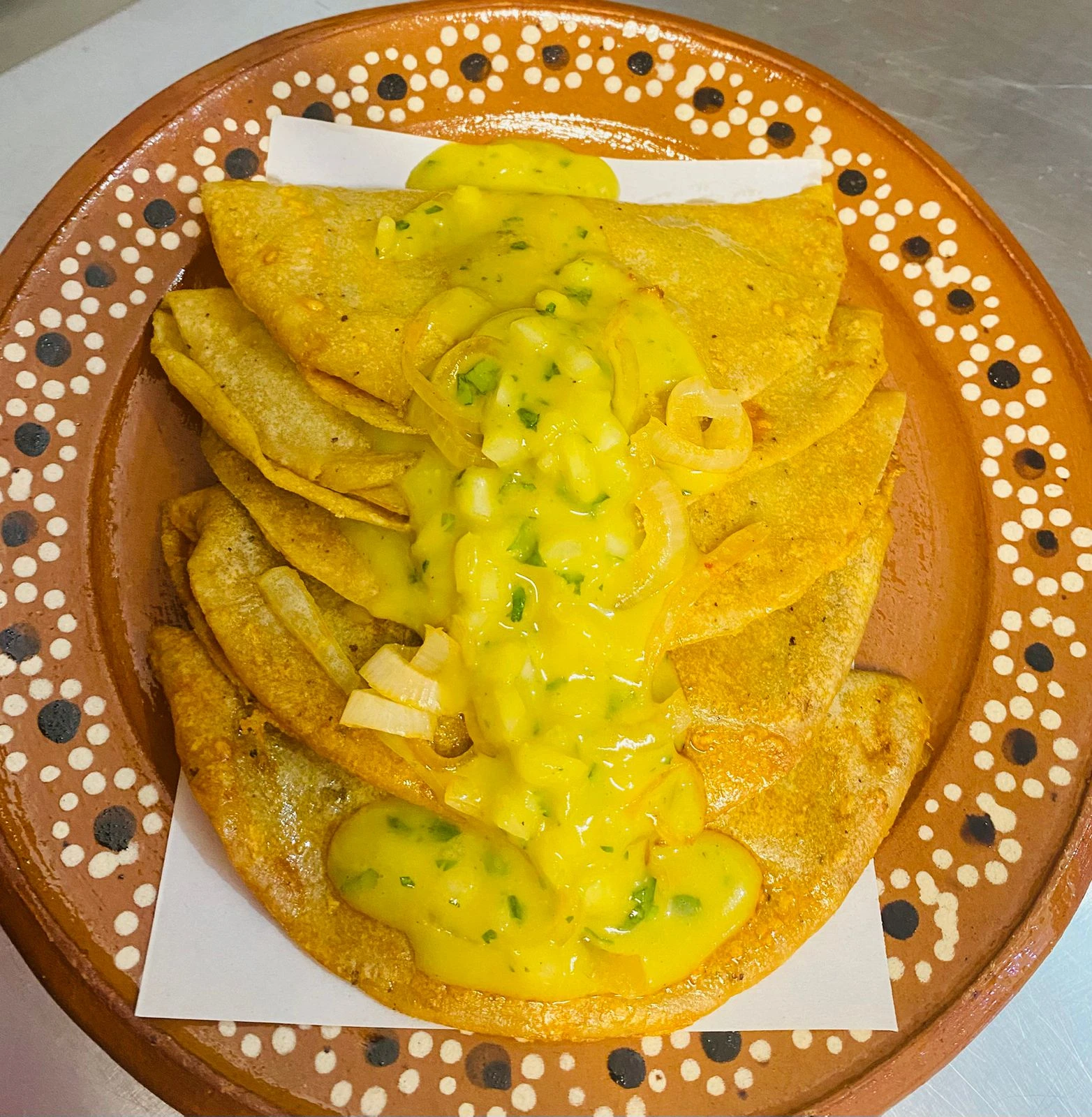 Tacos con salsa verde en plato de barro