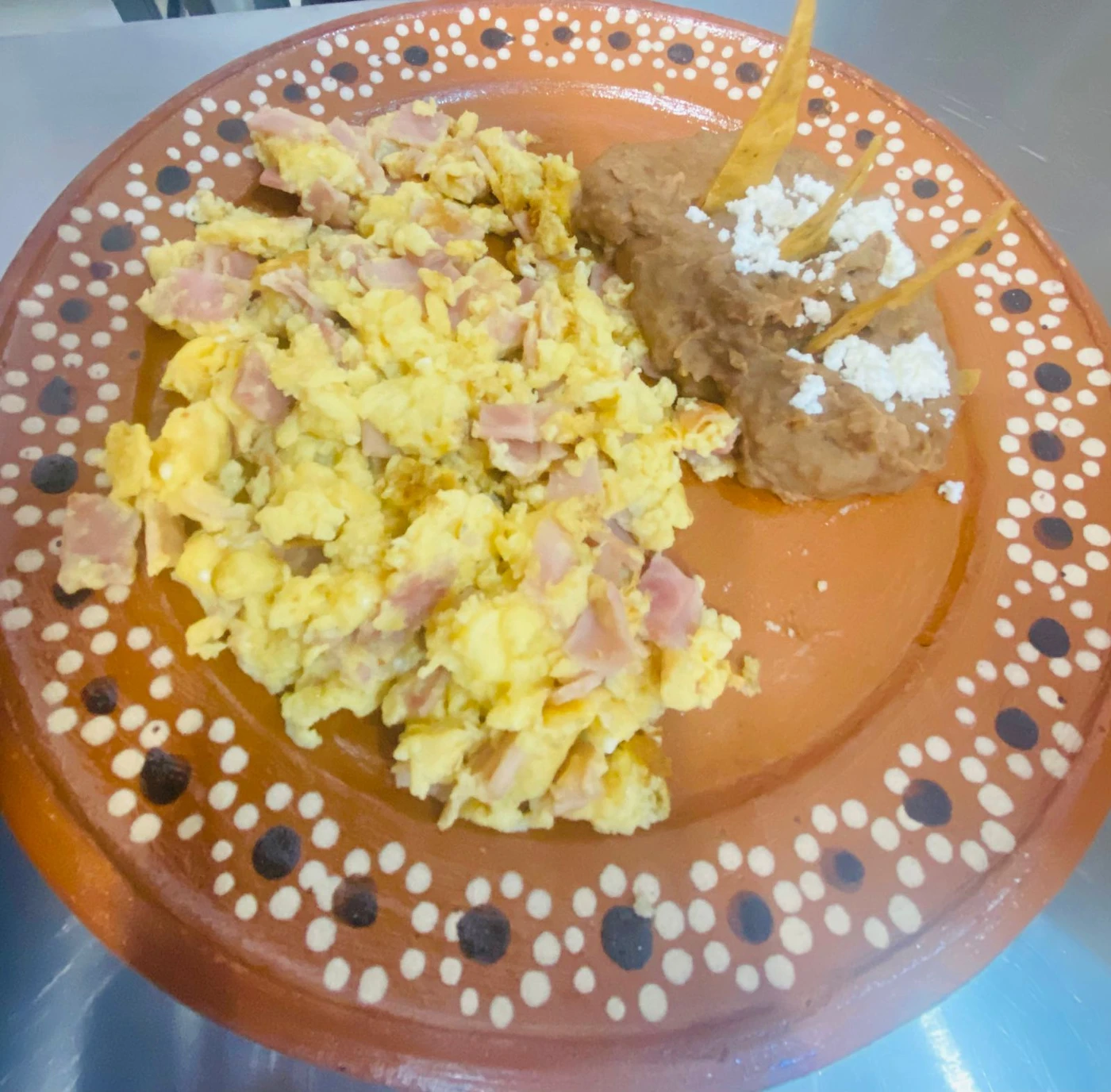 Huevos preparados con frijoles en plato de barro