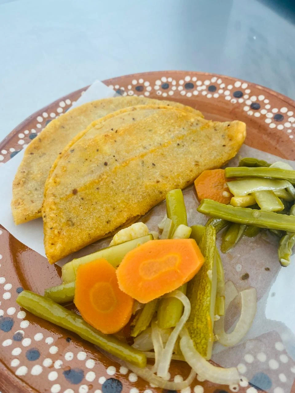 Tacos de La Canasta de la Abuela servidos en plato de barro con verduras